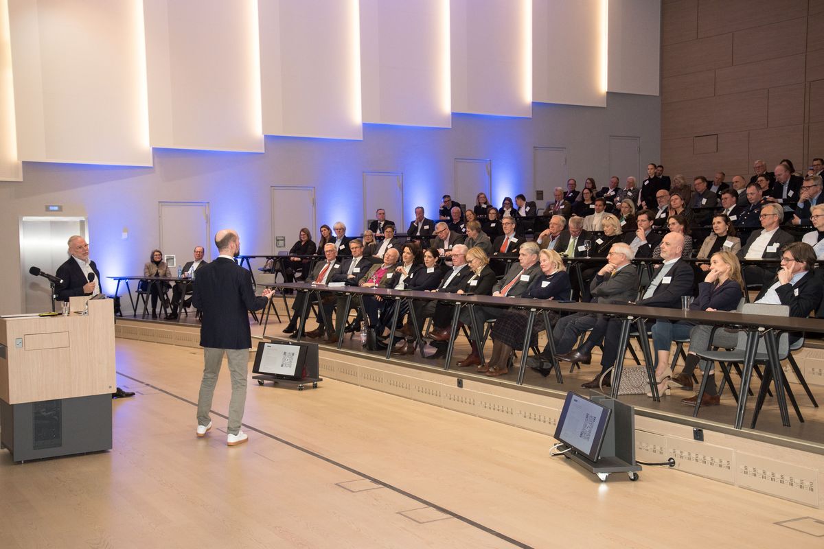 Christian Schulze on stage in front of the full auditorium of the Hessischer Kreis